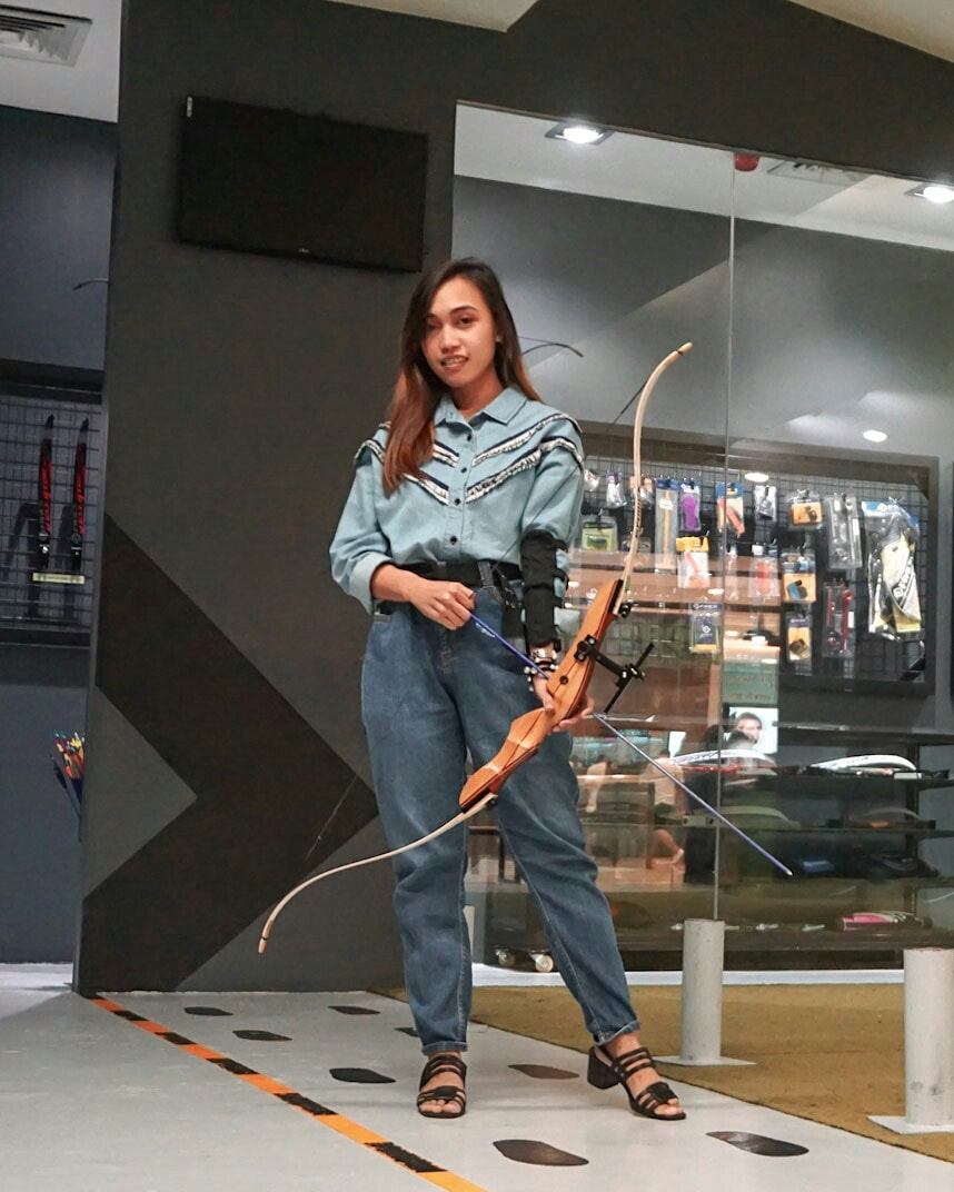 Female archer holding a Gandiva bow at Arrowland